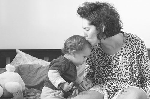 Mother kissing her baby daughter